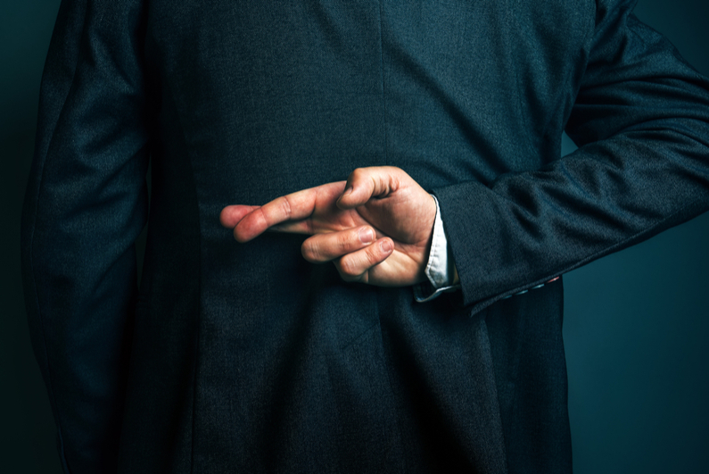 Dishonest businessman lying and holding fingers crossed behind his back