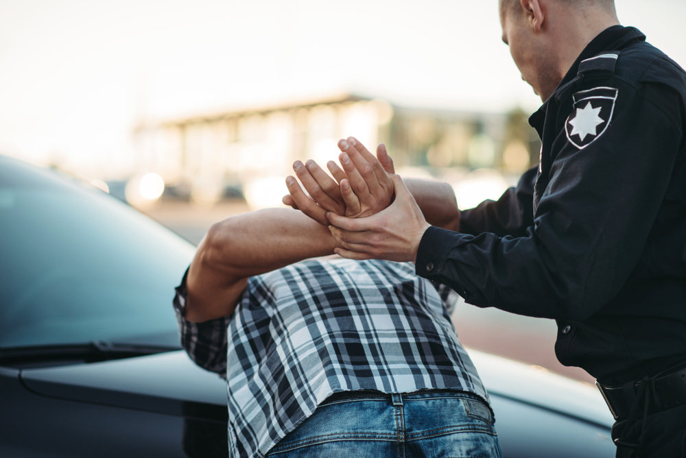 police officer arresting man using handcuffs