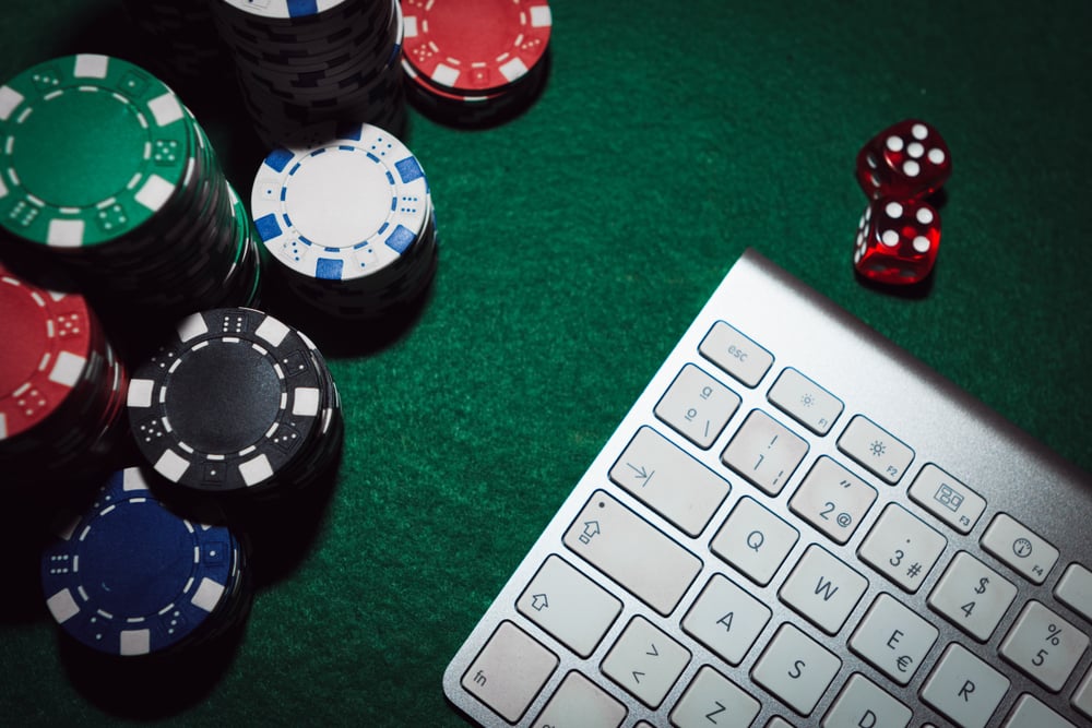 poker chips and computer keyboard on green felt