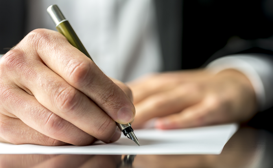 businessman in a suit signing a letter